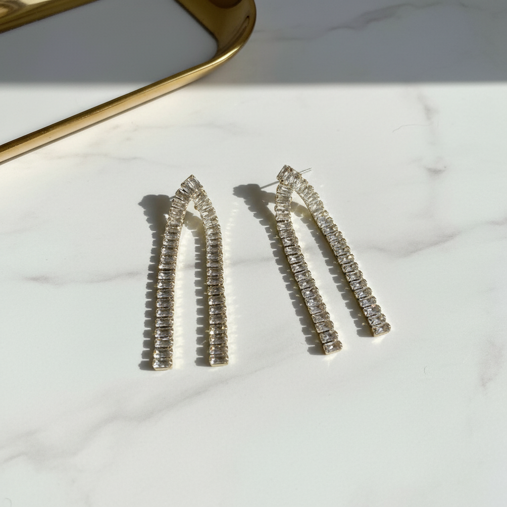 Ασημένια κρυστάλλινα σκουλαρίκια με καμπύλη, flatlay σε λευκό μάρμαρο