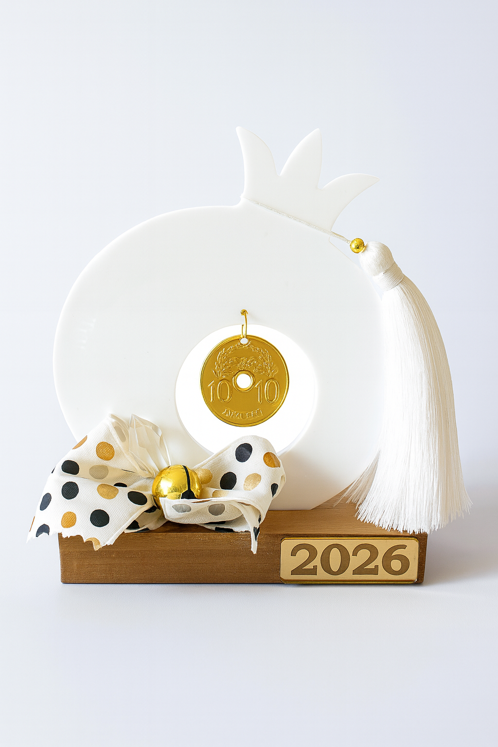 Decorative item with a white owl, gold tag, and polka dot ribbon on a white background