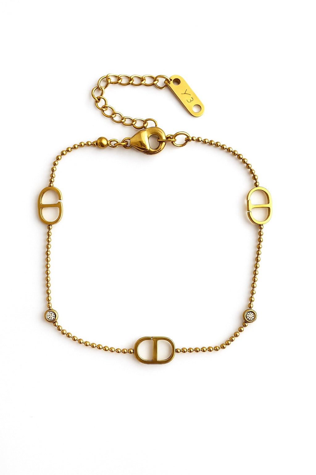 Ατσάλινο χρυσό βραχιόλι με ζιργκόν και διακοσμητικά στοιχεία σε σχήμα D, φωτογραφημένο σε λευκό φόντο.