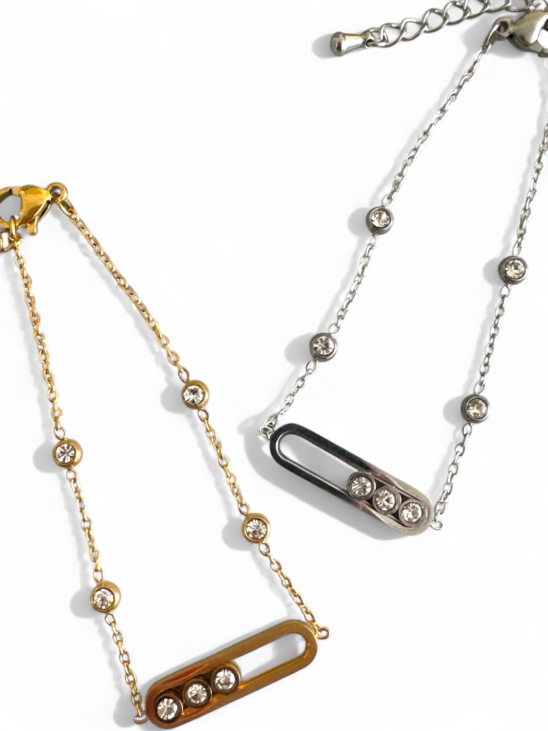 Ατσάλινα βραχιόλια με ζιργκόν σε χρυσό και ασημί χρώμα, σε φόντο λευκό