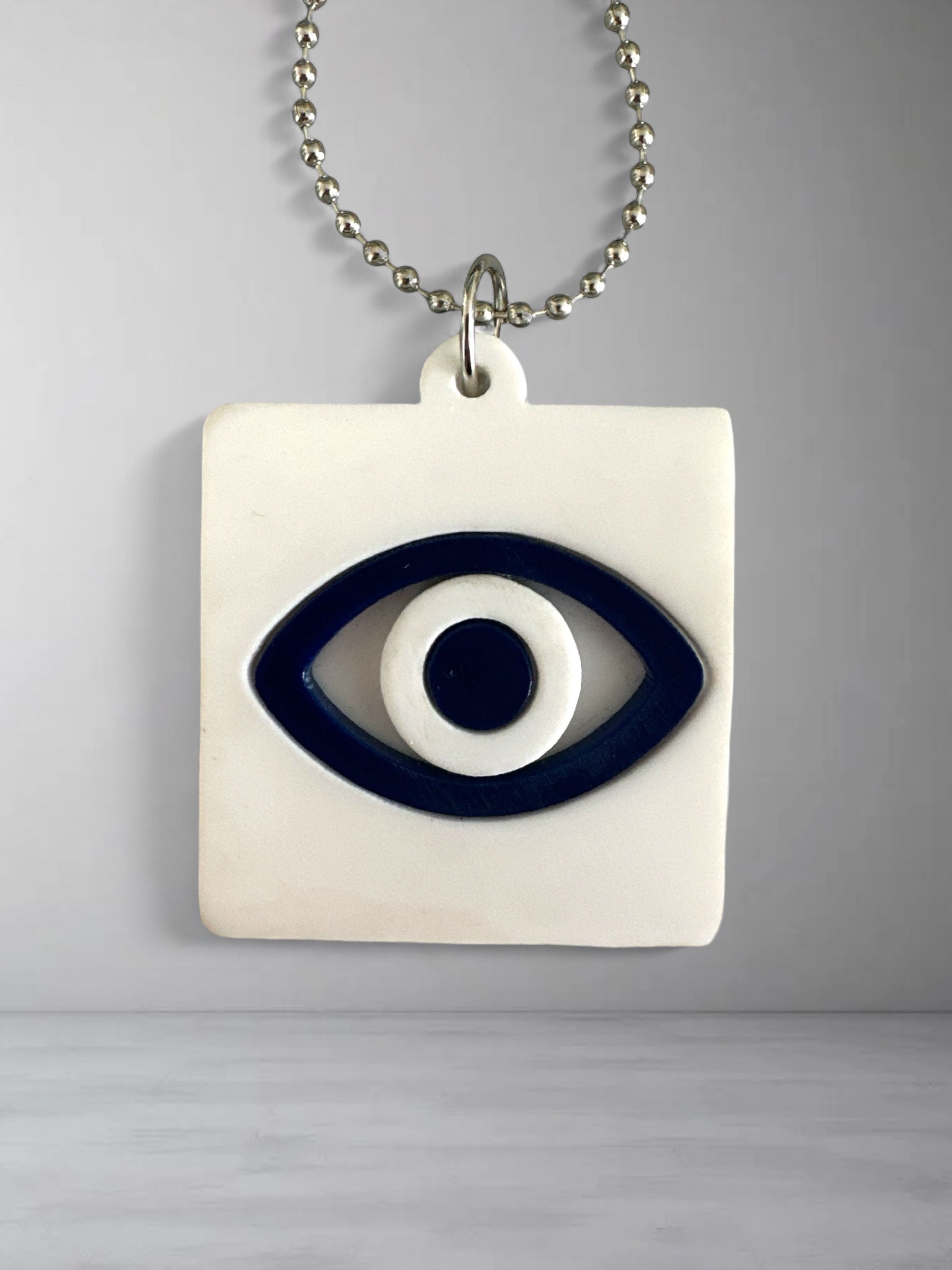 Γούρι αυτοκινήτου σε τετράγωνο σχήμα με μάτι σε λευκό και navy blue πλέξιγκλας και μεταλλική αλυσίδα