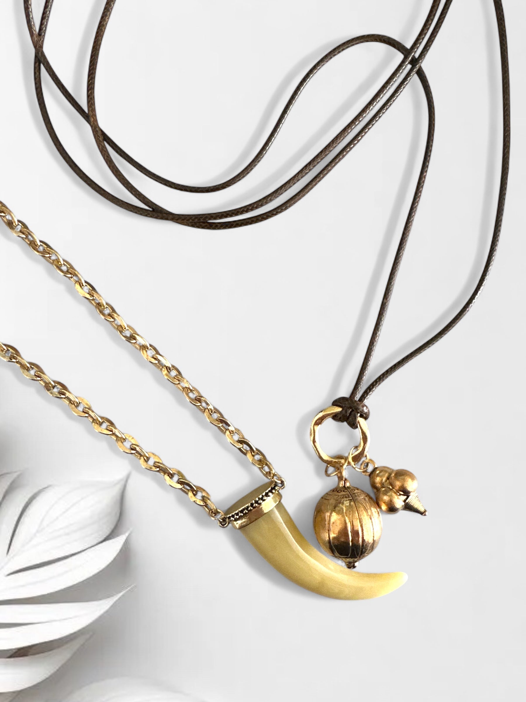 Σετ δύο boho κολιέ So Cute By Dimi: ένα με ακρυλικό δόντι σε χρυσή αλυσίδα και ένα πολύ μακρύ κορδόνι με χρυσά μεταλλικά στοιχεία.