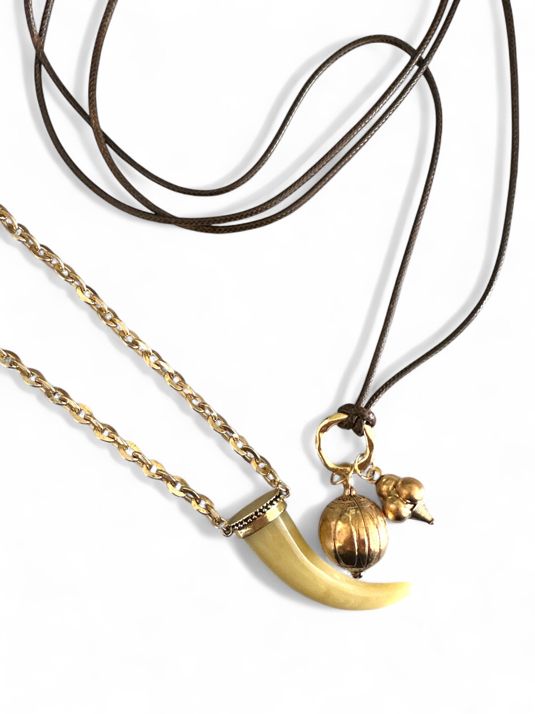 Σετ δύο boho κολιέ So Cute By Dimi: ένα με ακρυλικό δόντι σε χρυσή αλυσίδα και ένα πολύ μακρύ κορδόνι με χρυσά μεταλλικά στοιχεία.