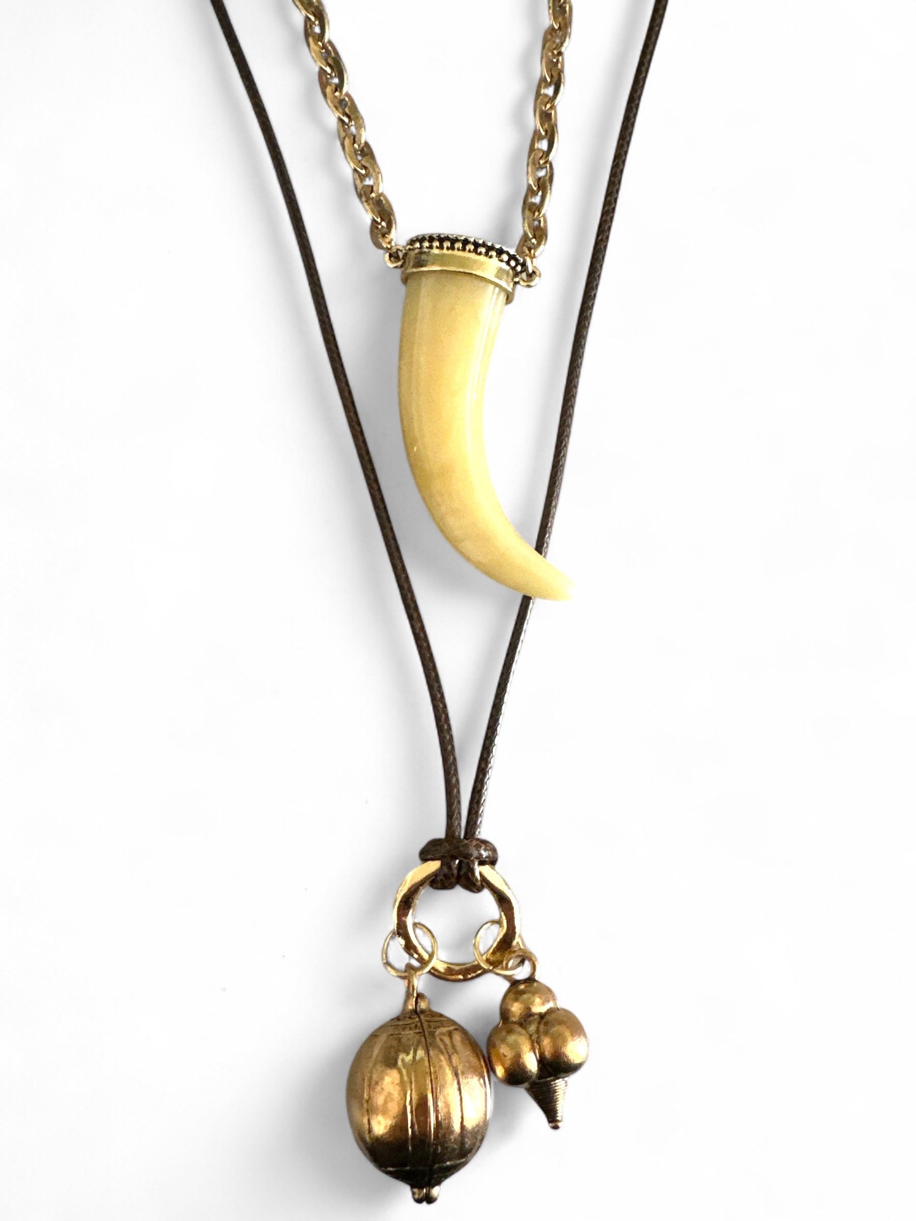 Σετ δύο boho κολιέ So Cute By Dimi: ένα με ακρυλικό δόντι σε χρυσή αλυσίδα και ένα πολύ μακρύ κορδόνι με χρυσά μεταλλικά στοιχεία.