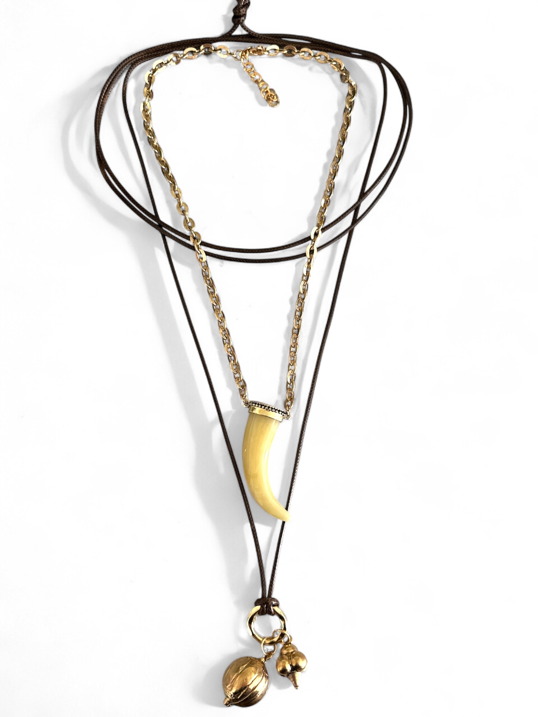 Σετ δύο boho κολιέ So Cute By Dimi: ένα με ακρυλικό δόντι σε χρυσή αλυσίδα και ένα πολύ μακρύ κορδόνι με χρυσά μεταλλικά στοιχεία.