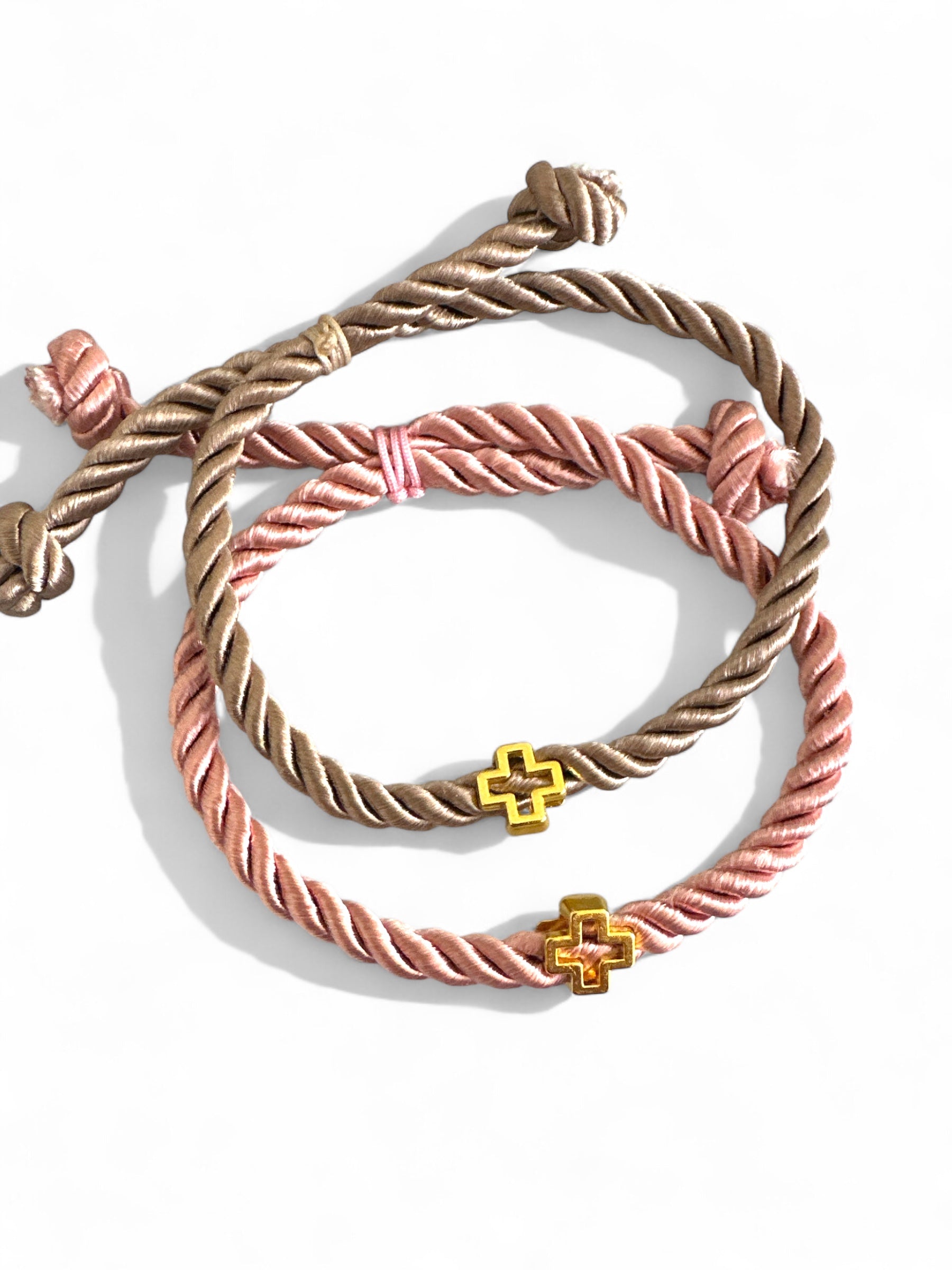 Χειροποίητα μαρτυρικά βραχιόλια από στριφτό σατέν κορδόνι και χρυσό σταυρουδάκι – σε dusty pink & μπεζ αποχρώσεις.