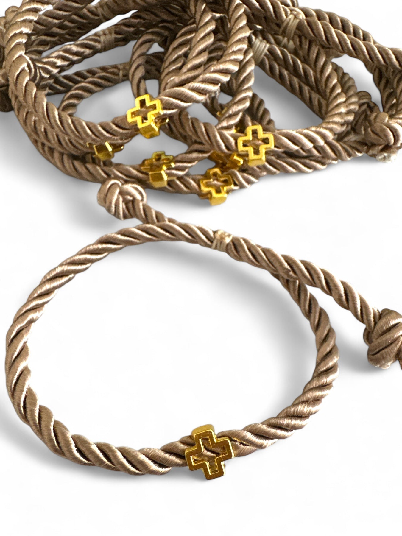 Χειροποίητα μαρτυρικά βραχιόλια από στριφτό σατέν κορδόνι και χρυσό σταυρουδάκι – σε μπεζ απόχρωση.