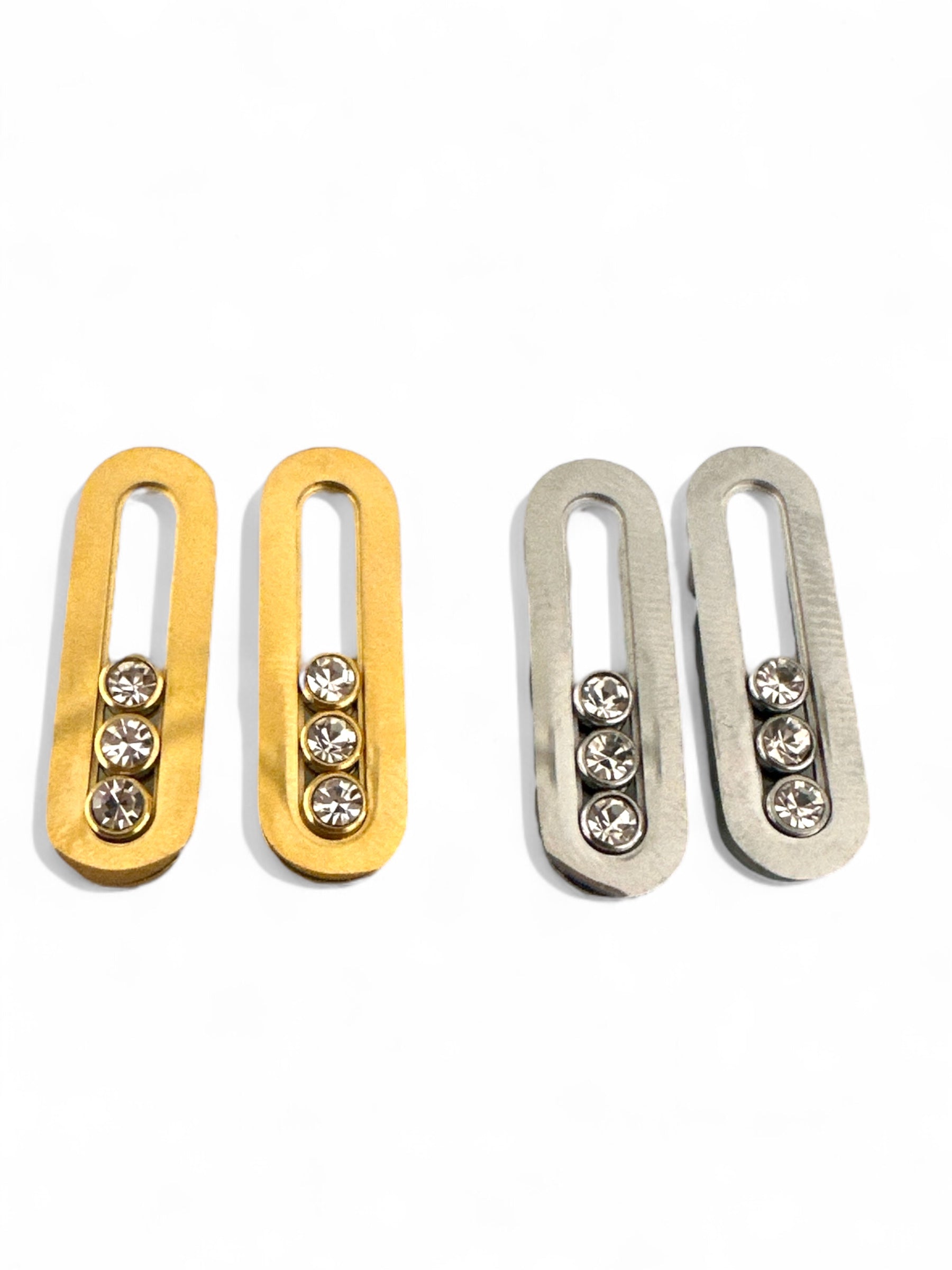Ατσάλινα σκουλαρίκια σε σχήμα κάθετου οβάλ με τριπλό ζιργκόν, σε χρυσό και ασημί χρώμα. So Cute by Dimi