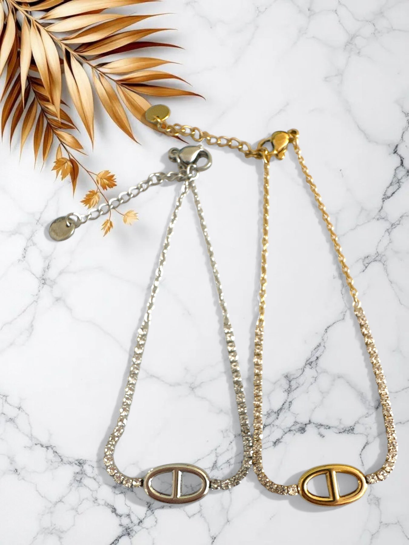 Ατσάλινα βραχιόλια με στρας και χρυσό/ασημί μοτίφ τύπου θ, σε μαρμάρινο φόντο. So Cute by Dimi