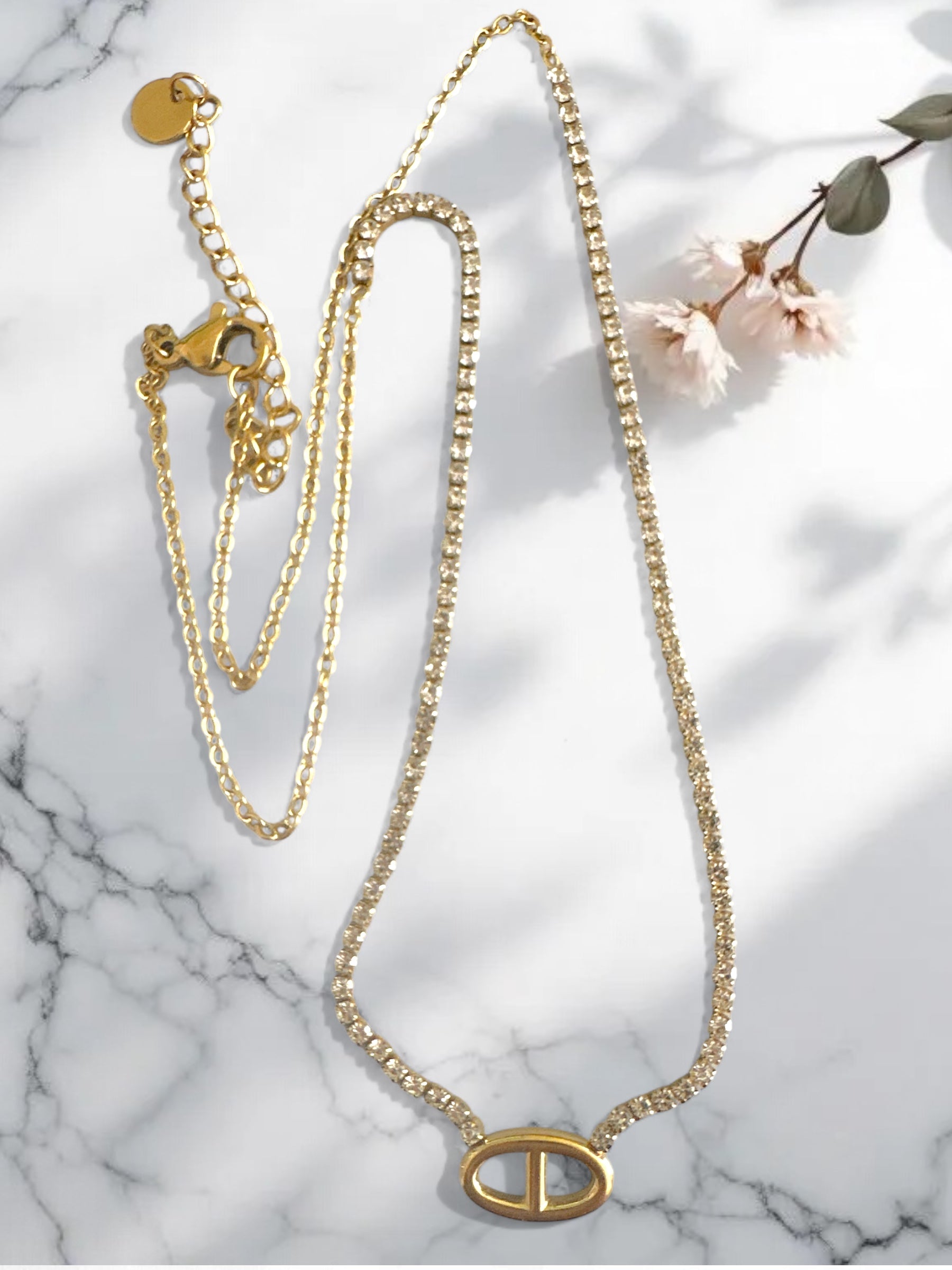 Ατσάλινο χρυσό κολιέ με στρας και μοτίφ οβάλ σε λευκό φόντο με λουλούδια-So Cute by Dimi