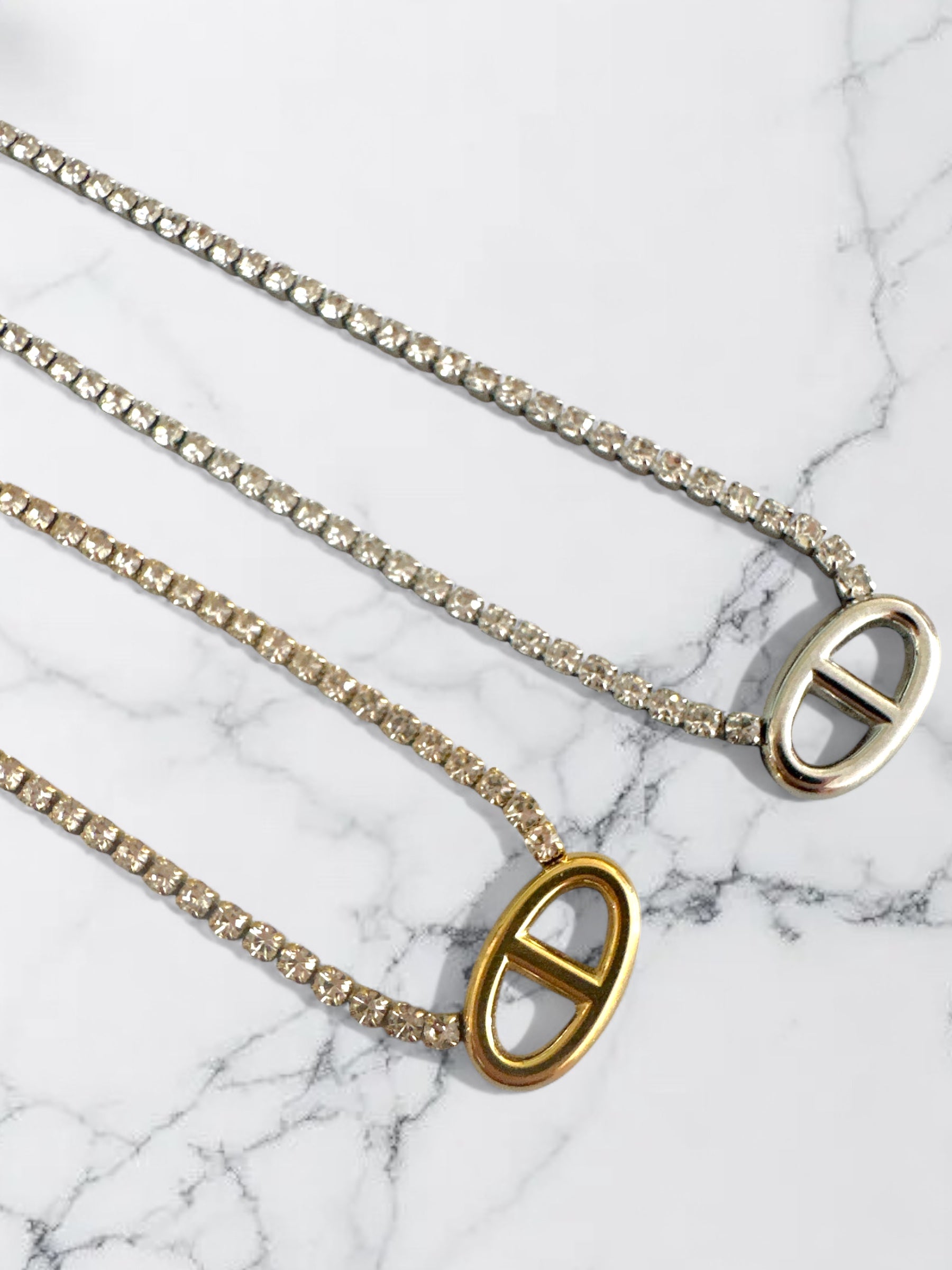 Ατσάλινα κολιέ με στρας σε χρυσό και ασημι χρώμα και μοτίφ οβάλ σε λευκό φόντο με λουλούδια-So Cute by DImi