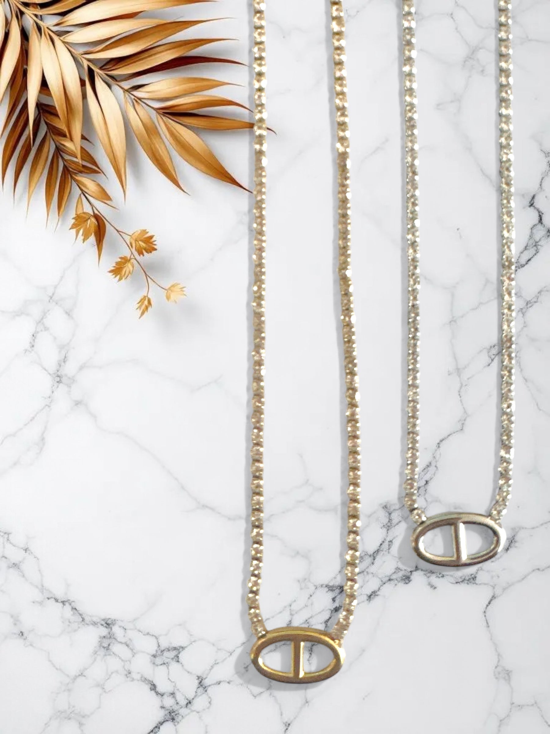 Ατσάλινα κολιέ με στρας σε χρυσό και ασημι χρώμα και μοτίφ οβάλ σε λευκό φόντο με λουλούδια-So Cute by DImi