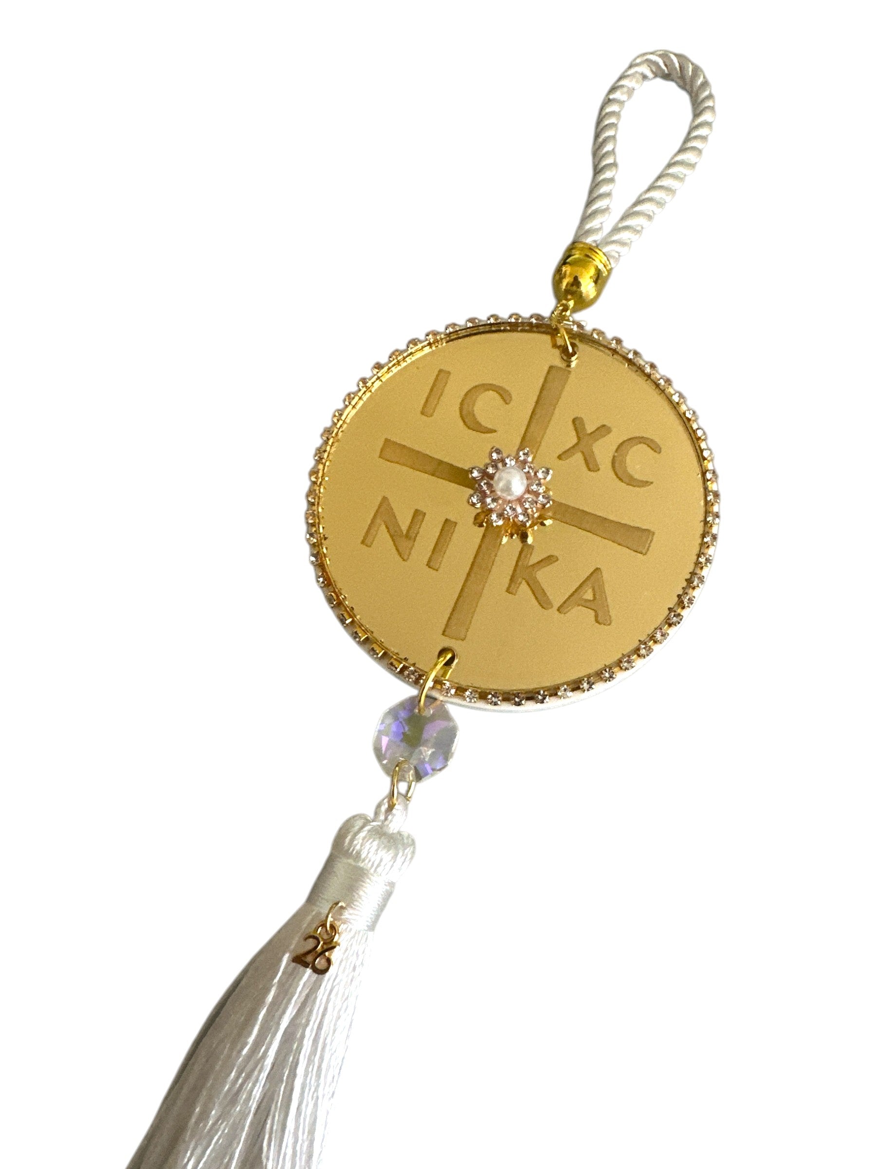 Χρυσό IC XC NIKA γούρι τοποθετημένο σε minimal flatlay.