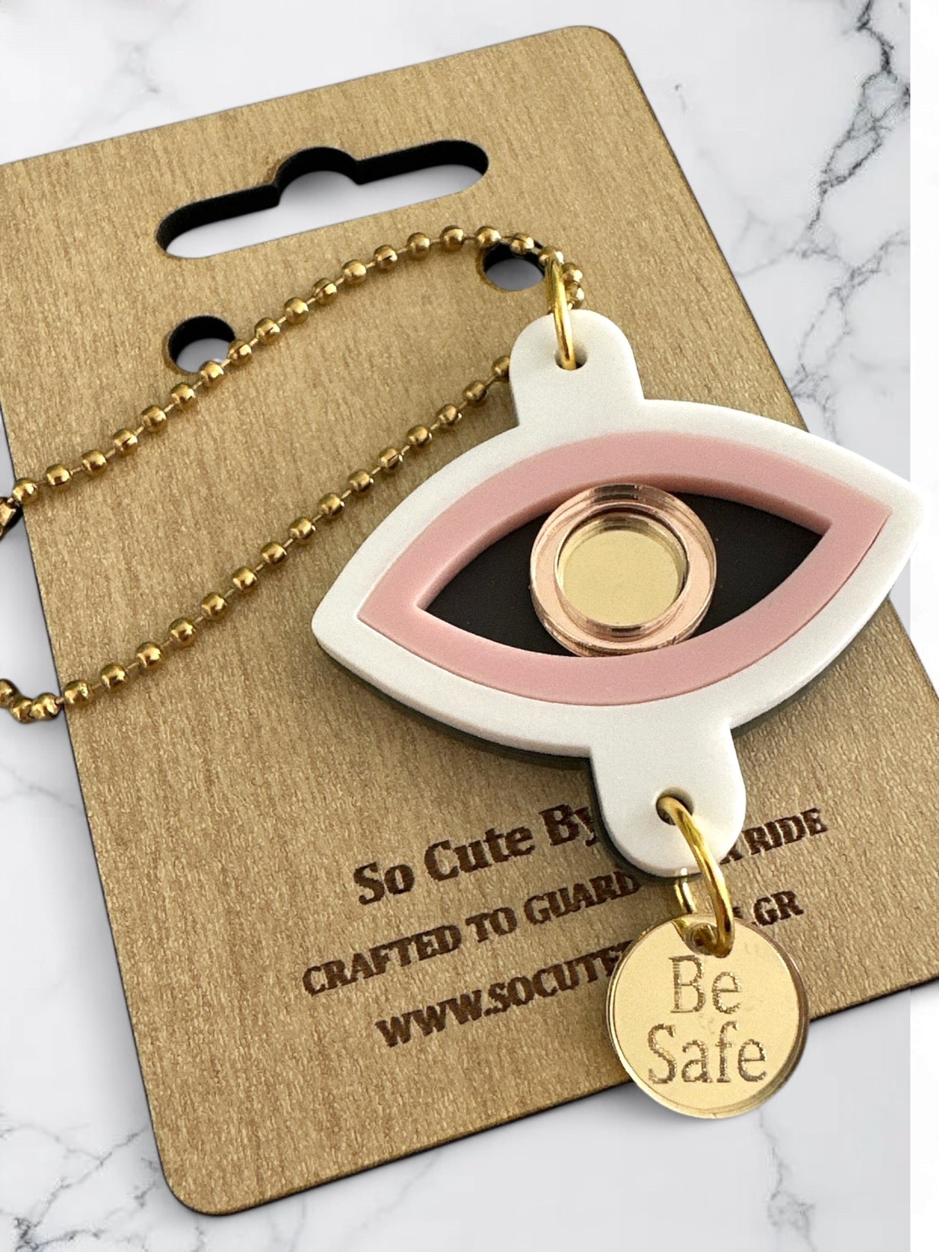 Γούρι αυτοκινήτου σε σχήμα ματιού με blush pink λεπτομέρεια, χρυσό καθρέφτη στο κέντρο και plexiglass charm Be Safe