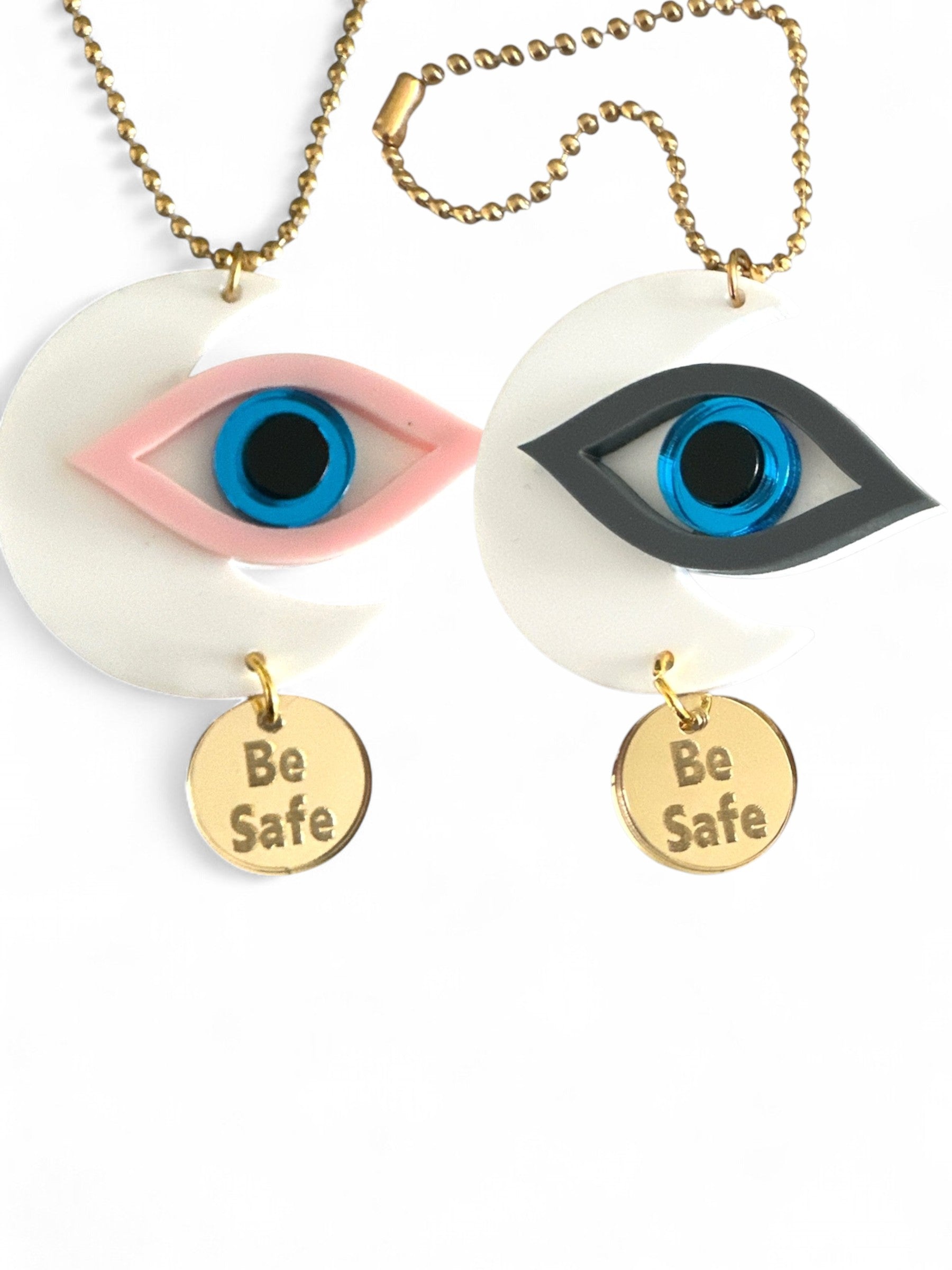 Γούρια αυτοκινήτου σε σχήμα μισοφέγγαρου με μάτι σε ροζ και γκρι πλέξιγκλας, μπλε διάφανο κέντρο και μεταλλικό charm “Be Safe”