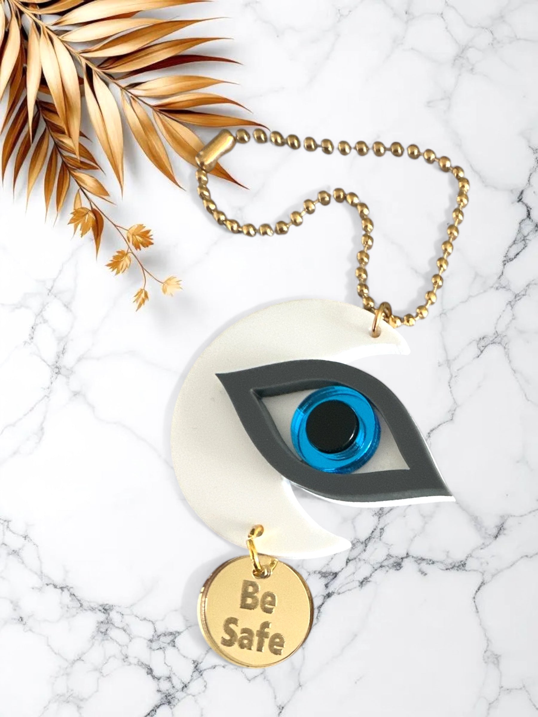 Γούρια αυτοκινήτου σε σχήμα μισοφέγγαρου με μάτι σε ροζ και γκρι πλέξιγκλας, μπλε διάφανο κέντρο και μεταλλικό charm “Be Safe”