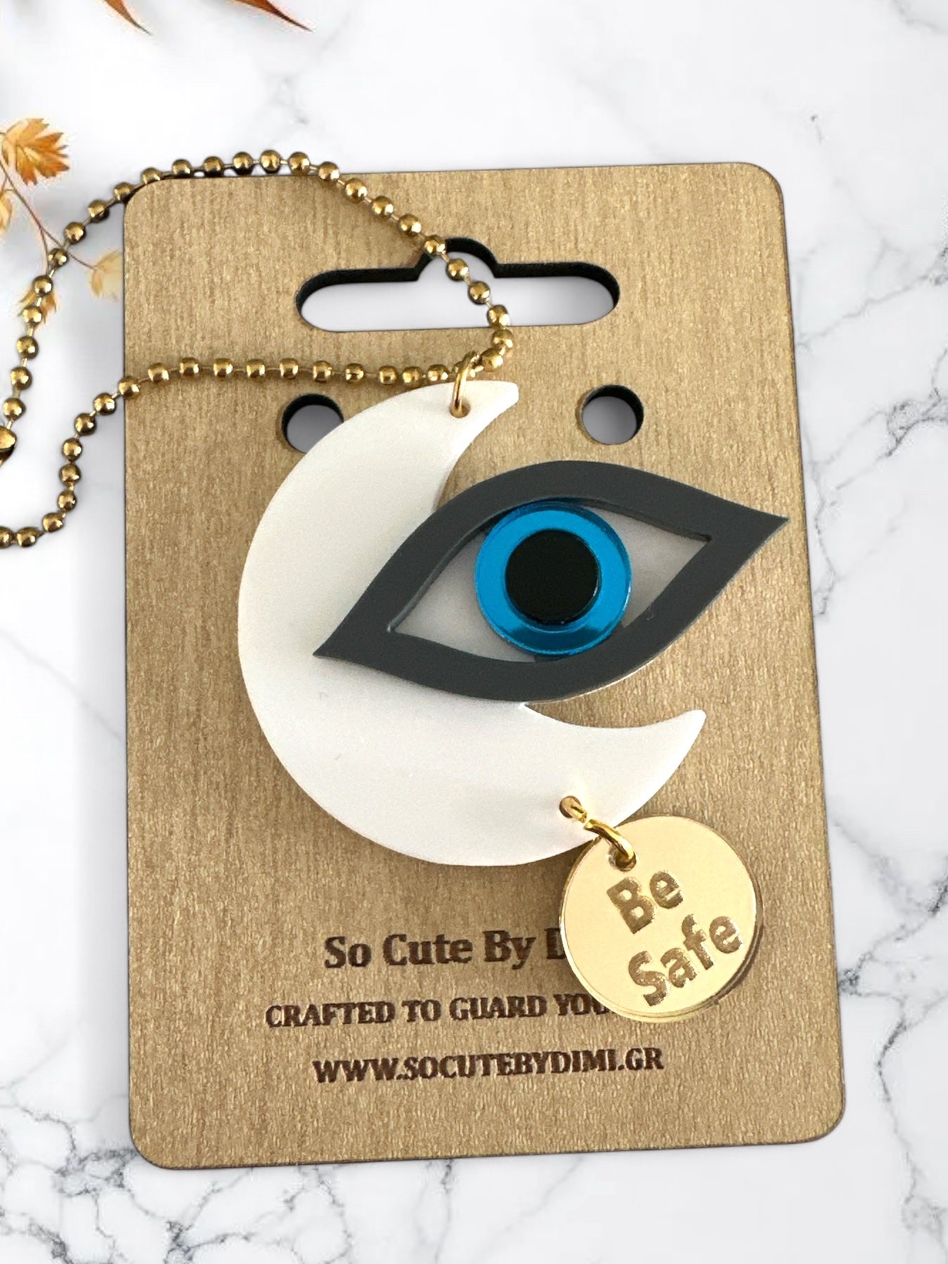 Γούρια αυτοκινήτου σε σχήμα μισοφέγγαρου με μάτι σε ροζ και γκρι πλέξιγκλας, μπλε διάφανο κέντρο και μεταλλικό charm “Be Safe”