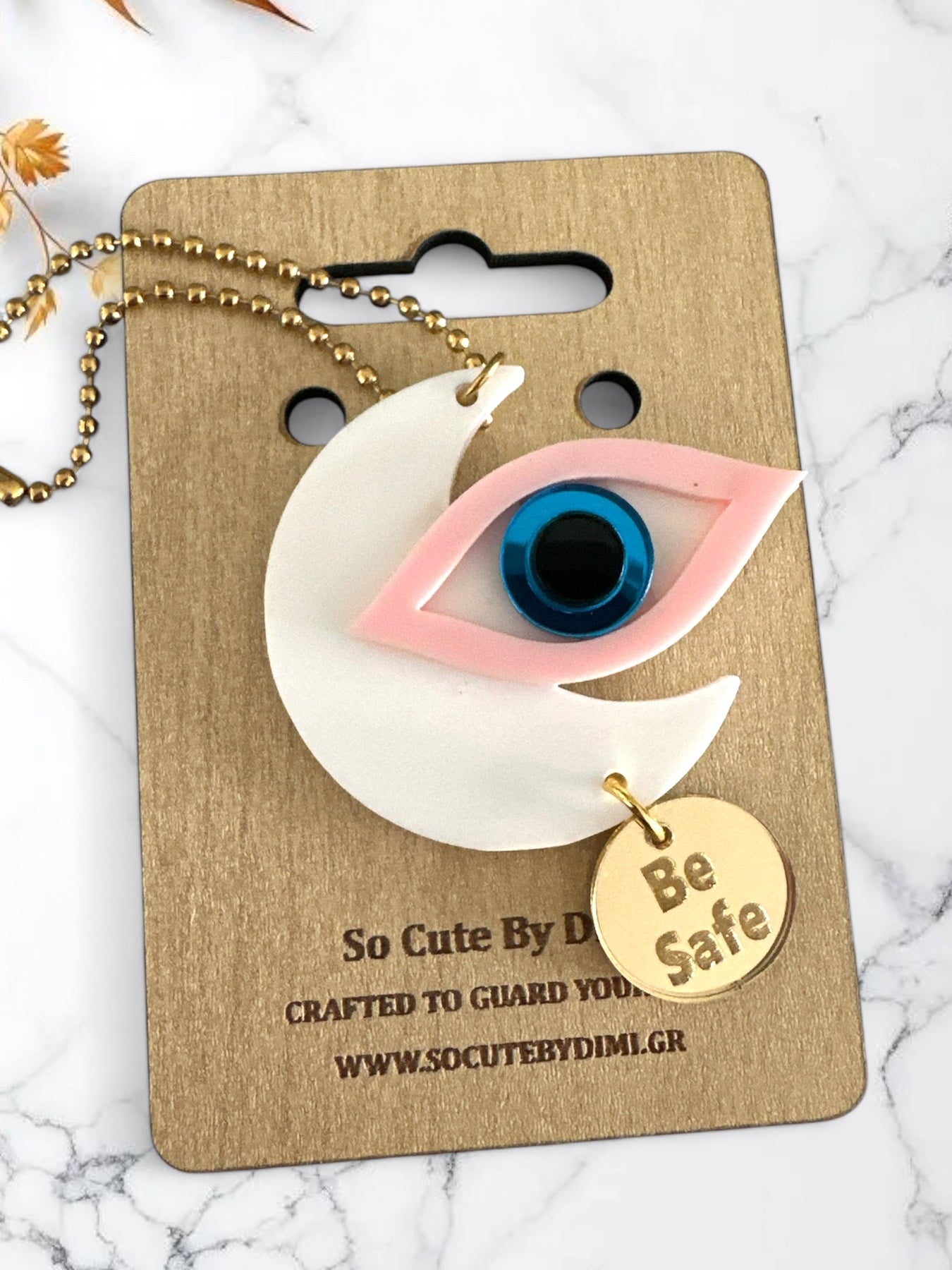 Γούρια αυτοκινήτου σε σχήμα μισοφέγγαρου με μάτι σε ροζ και γκρι πλέξιγκλας, μπλε διάφανο κέντρο και μεταλλικό charm “Be Safe”