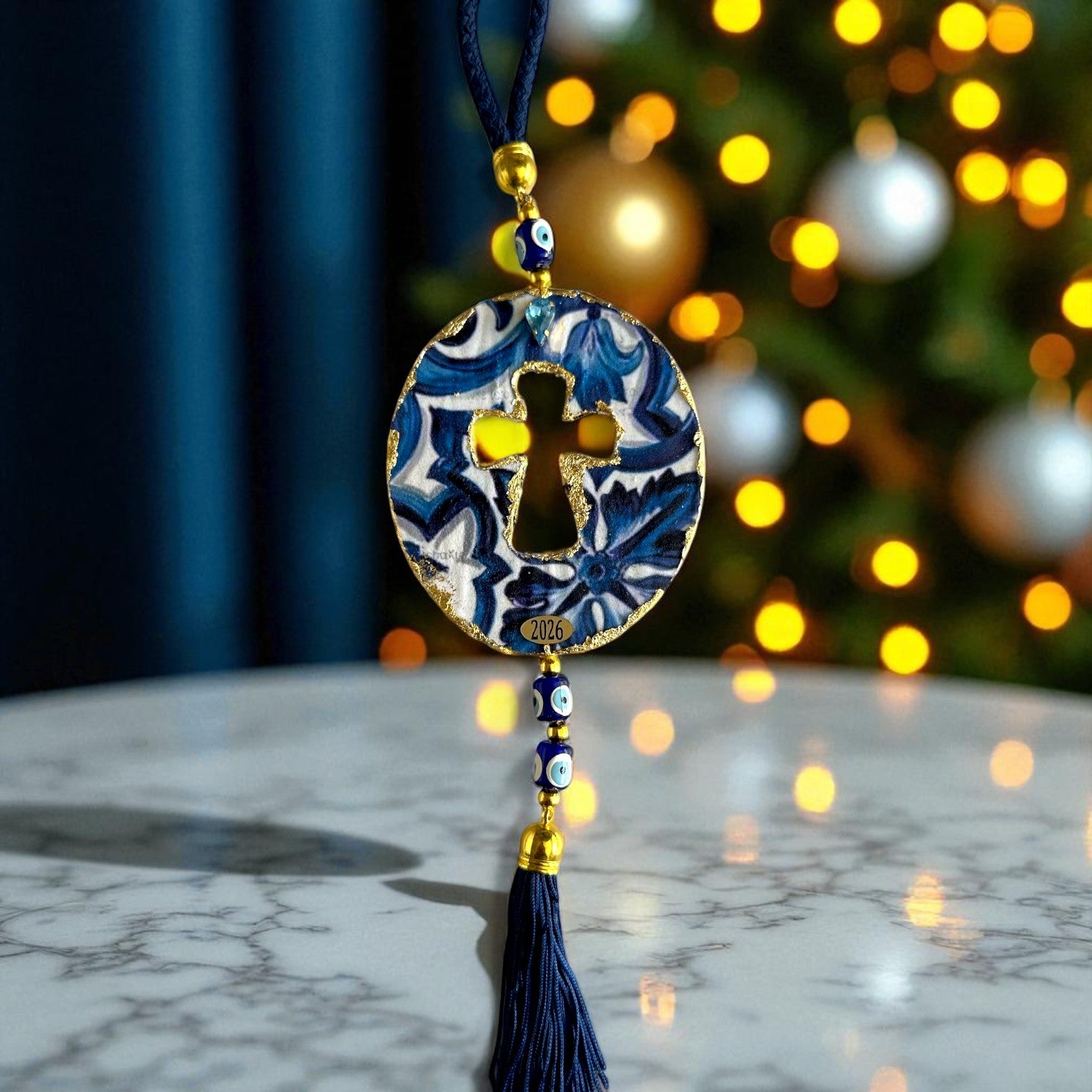 Γούρι 2026 οβάλ σταυρός με μάτια & φούντα – Greek Wishes Λιανική So Cute by Dimi