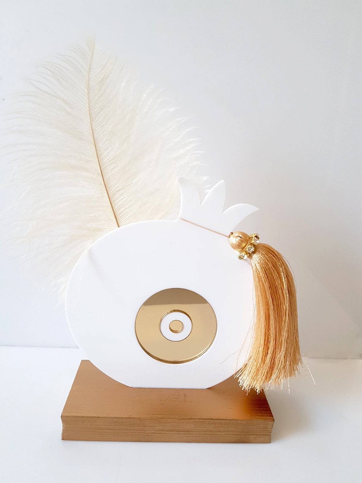 Χειροποίητο επιτραπέζιο γούρι ρόδι από plexiglass με χρυσό mirror μάτι, φτερό και φούντα με στρας, σε ξύλινη βάση, διαστάσεων 17×13 cm