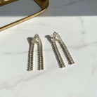 Ασημένια κρυστάλλινα σκουλαρίκια με καμπύλη, flatlay σε λευκό μάρμαρο