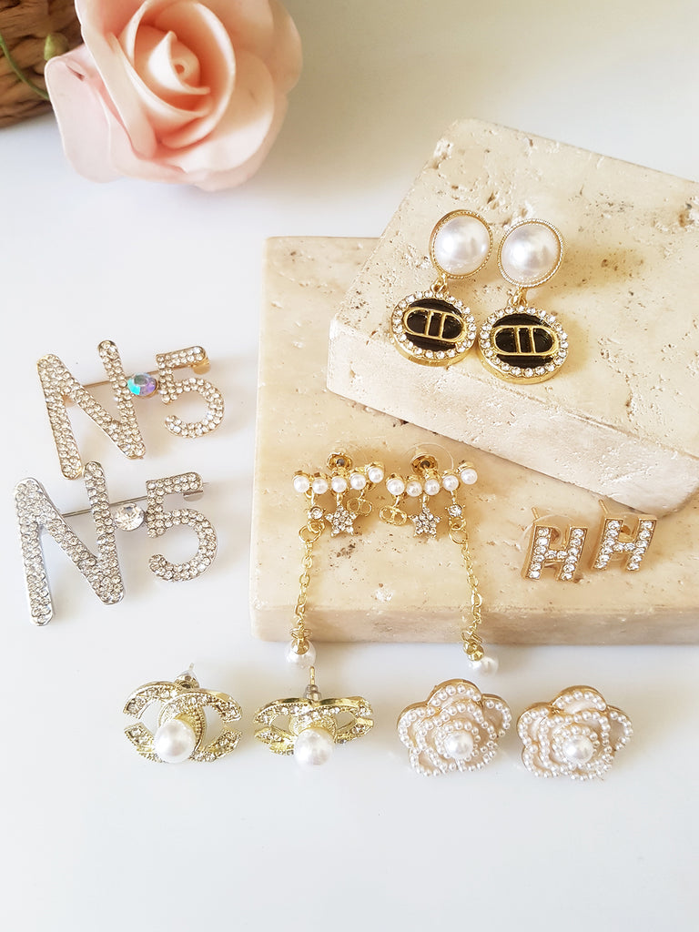 Ασύμμετρα σκουλαρίκια με πέρλες, ζιργκόν και λογότυπο