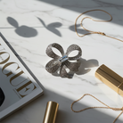 Μεταλλική καρφίτσα φιόγκος με strass σε ασημί χρώμα – So Cute by Dimi