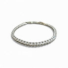 Silver bracelet with clear stones on a white background