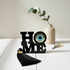 Επιτραπέζιο γούρι HOME με μάτι από πλεξιγκλάς και φούντα σε μαύρο χρώμα– So Cute by Dimi