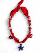 Necklace with red bandana, star-shaped blue pendant, and white beads on a white background