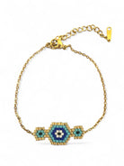Gold bracelet with a blue and green beaded design on a white background