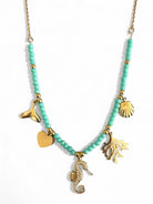 Necklace with turquoise beads and gold charms on a white background So Cute by DImi