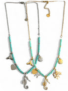 Two turquoise beaded necklaces with seahorse, shell, and starfish charms on a white background. So Cute by DImi