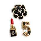 Set από τρεις mini fashion καρφίτσες – μαύρη καμέλια, κόκκινο lipstick και χρυσό νούμερο 5 – σε girly glam αισθητική