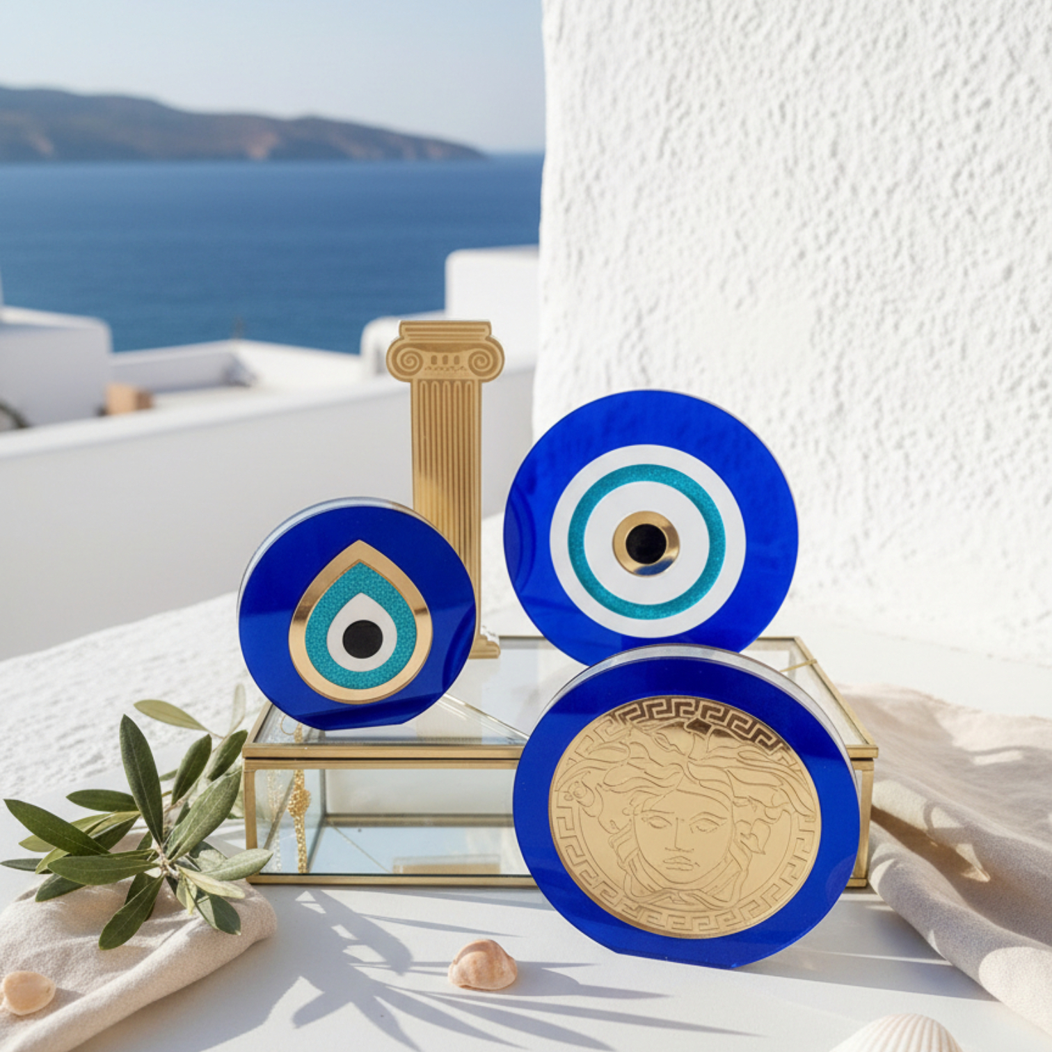 Σετ από μπλε plexiglass γούρια μάτι και χρυσές λεπτομέρειες σε κυκλαδίτικη ταράτσα με θέα θάλασσα