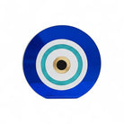 Επιτραπέζιο γούρι μάτι από μπλε και λευκό plexiglass με τιρκουάζ glitter λεπτομέρεια και χρυσό κέντρο σε λευκό φόντο.