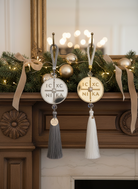 Χρυσά και ασημένια γούρια IC XC NIKA κρεμασμένα σε διακόσμηση τζακιού με festive chic ύφος.