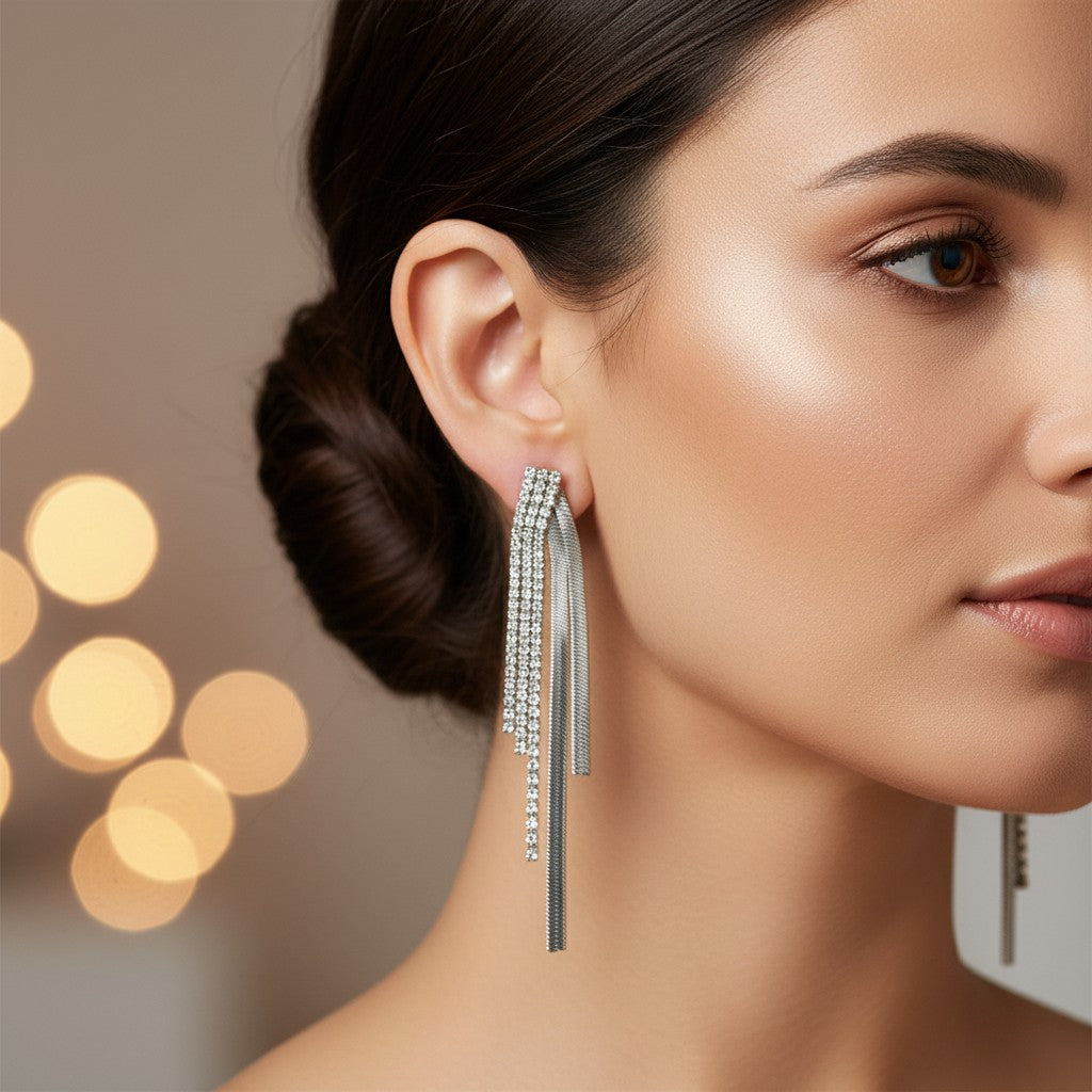 Close-up of a woman wearing a silver earring with tassels against a blurred background