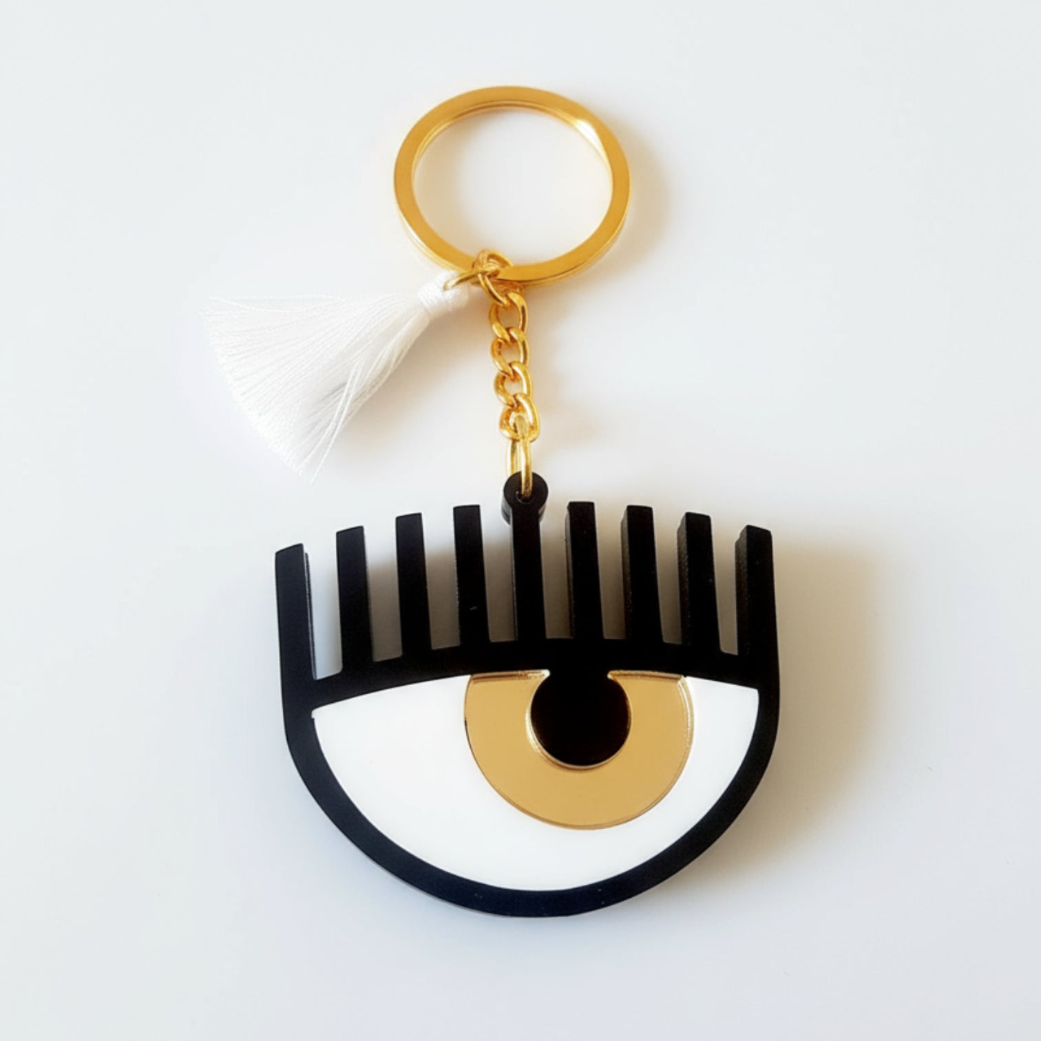 Plexiglass μπρελόκ μάτι με βλέφαρα και φουντίτσα σε μπλε ή χρυσό χρώμα – So Cute by Dimi